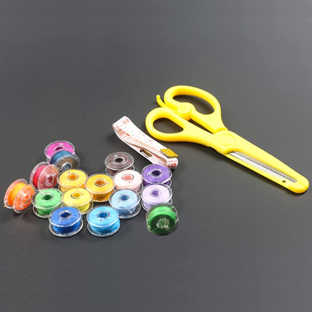 Sewing bobbins with thread, yellow scissors, and measuring tape on a dark background