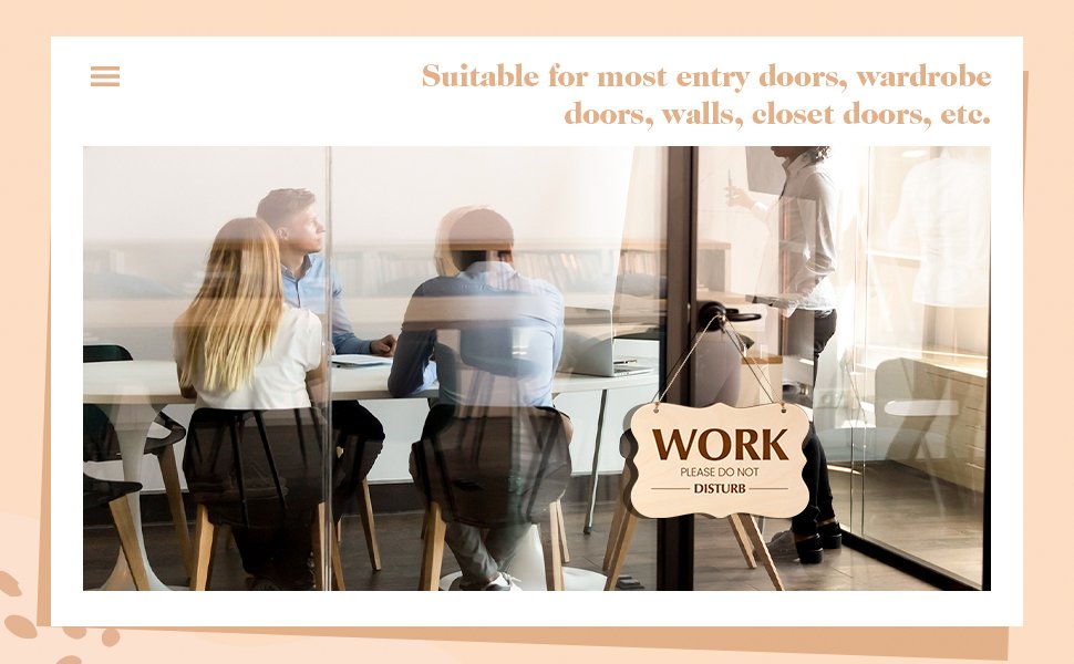 Wooden 'Work Please Do Not Disturb' sign hanging on a glass door in an office setting with people in a meeting.