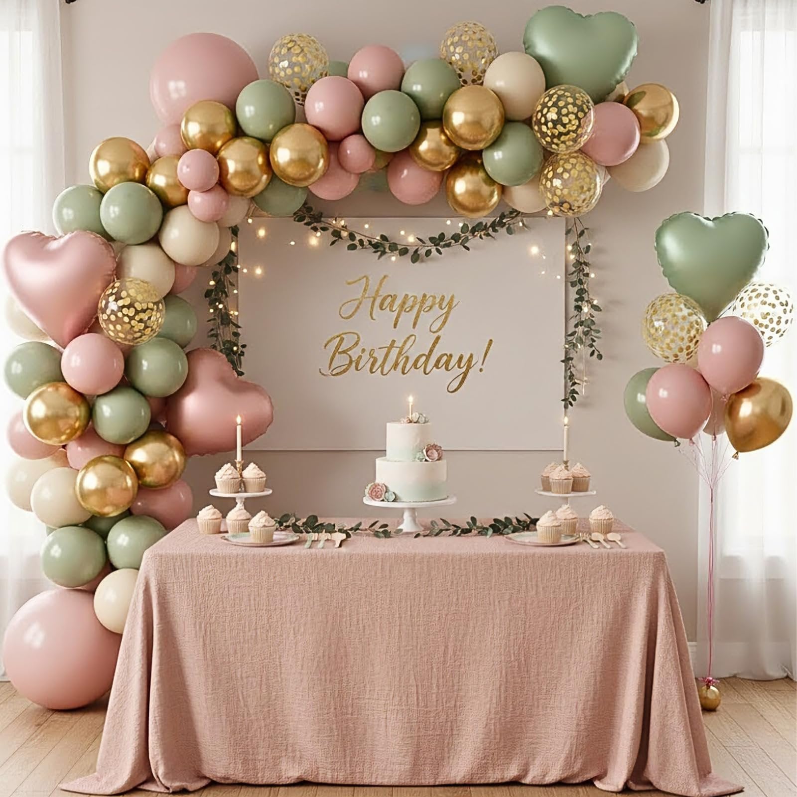 Birthday party table with cake and cupcakes decorated with a balloon arch and garland