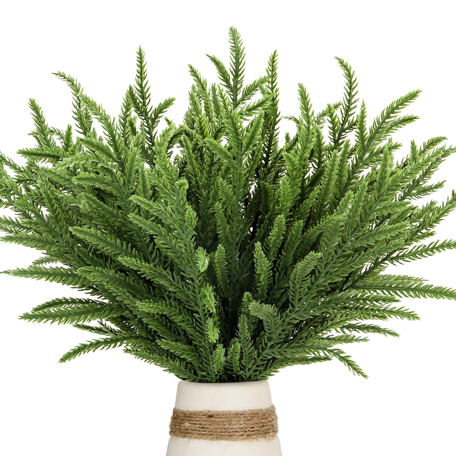 Green faux evergreen sprigs in a white vase with twine detail, close-up view