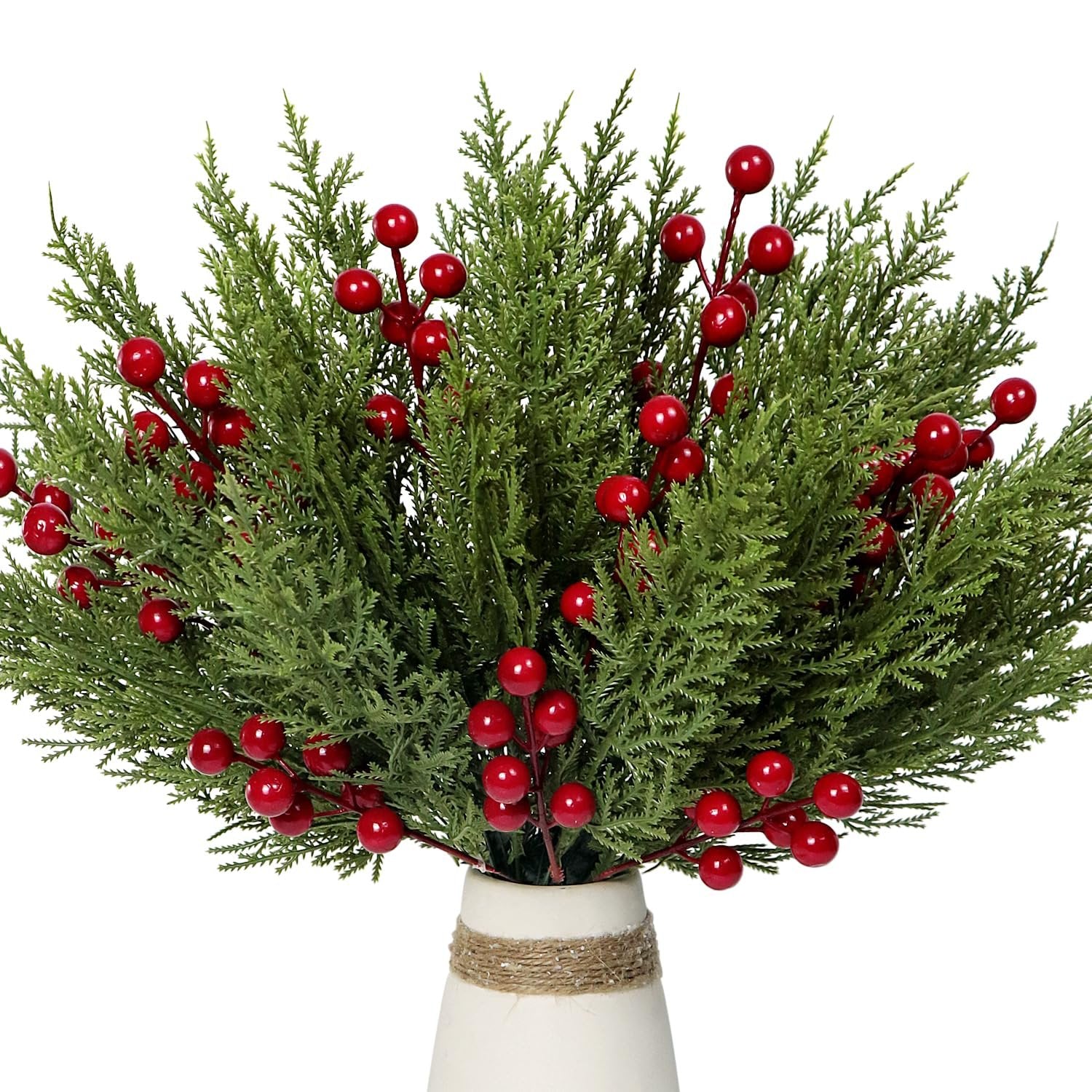 Artificial pine branches with red berries in a vase, close-up view