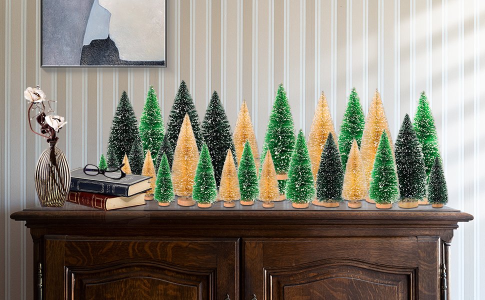 Assortment of 30 mini snowy bottle brush Christmas trees in green and gold with wooden bases displayed on a dresser.