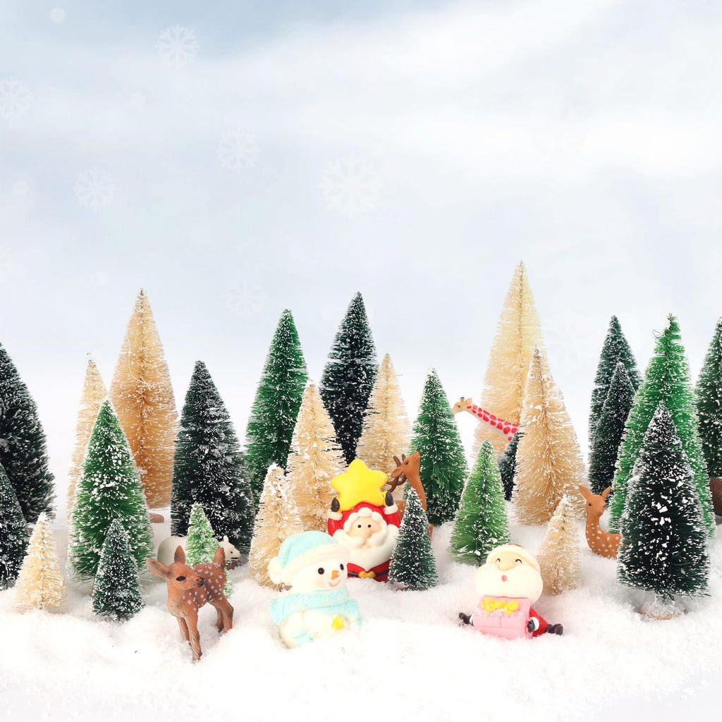 Miniature Christmas trees with Santa, snowman, and deer figures in a snowy scene.