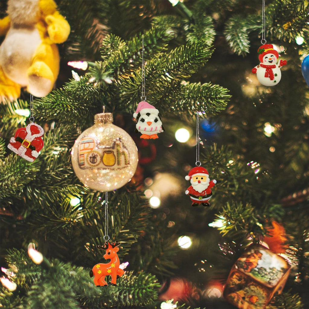 Assorted mini Christmas ornaments including Santa, snowman, penguin, and reindeer hanging on a decorated tree.