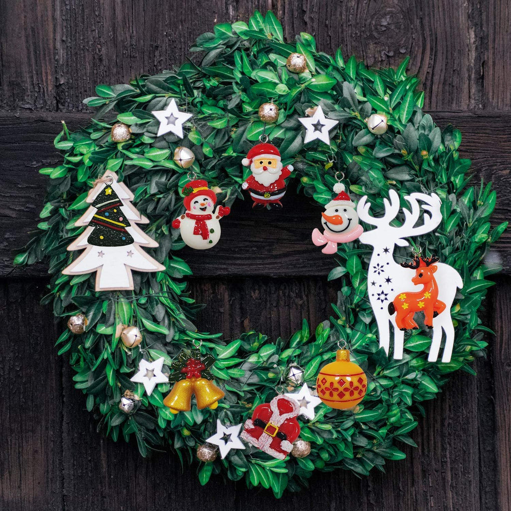 Christmas wreath with assorted mini ornaments including Santa, snowman, reindeer, and Christmas tree, hanging on a dark wooden door.