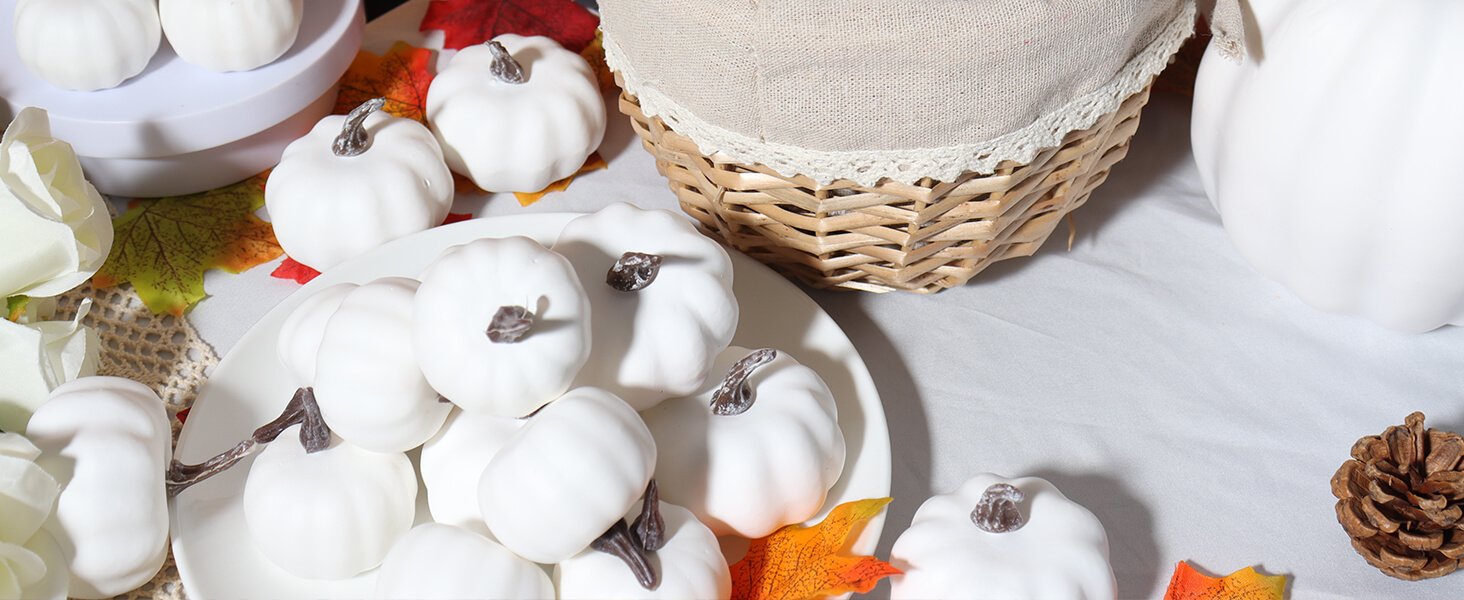 Assortment of small white plastic pumpkins arranged on a white plate and around a woven basket, with fall leaves and decorative flowers.