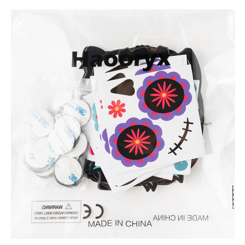 Day of the Dead magnet craft kit contents including stickers, foam shapes, and adhesive dots, inside a clear plastic bag.