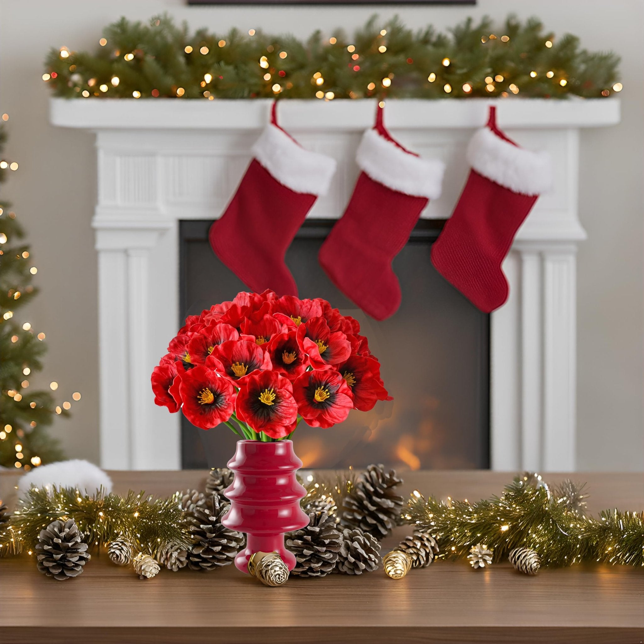 Red artificial poppies in a red vase on a wooden surface with Christmas decorations