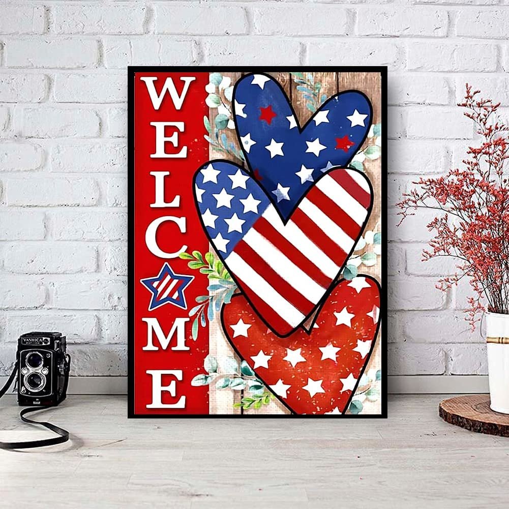 Independence Day themed diamond painting kit featuring the word WELCOME and three hearts in American flag colors, displayed on a table with a vintage camera and plant.
