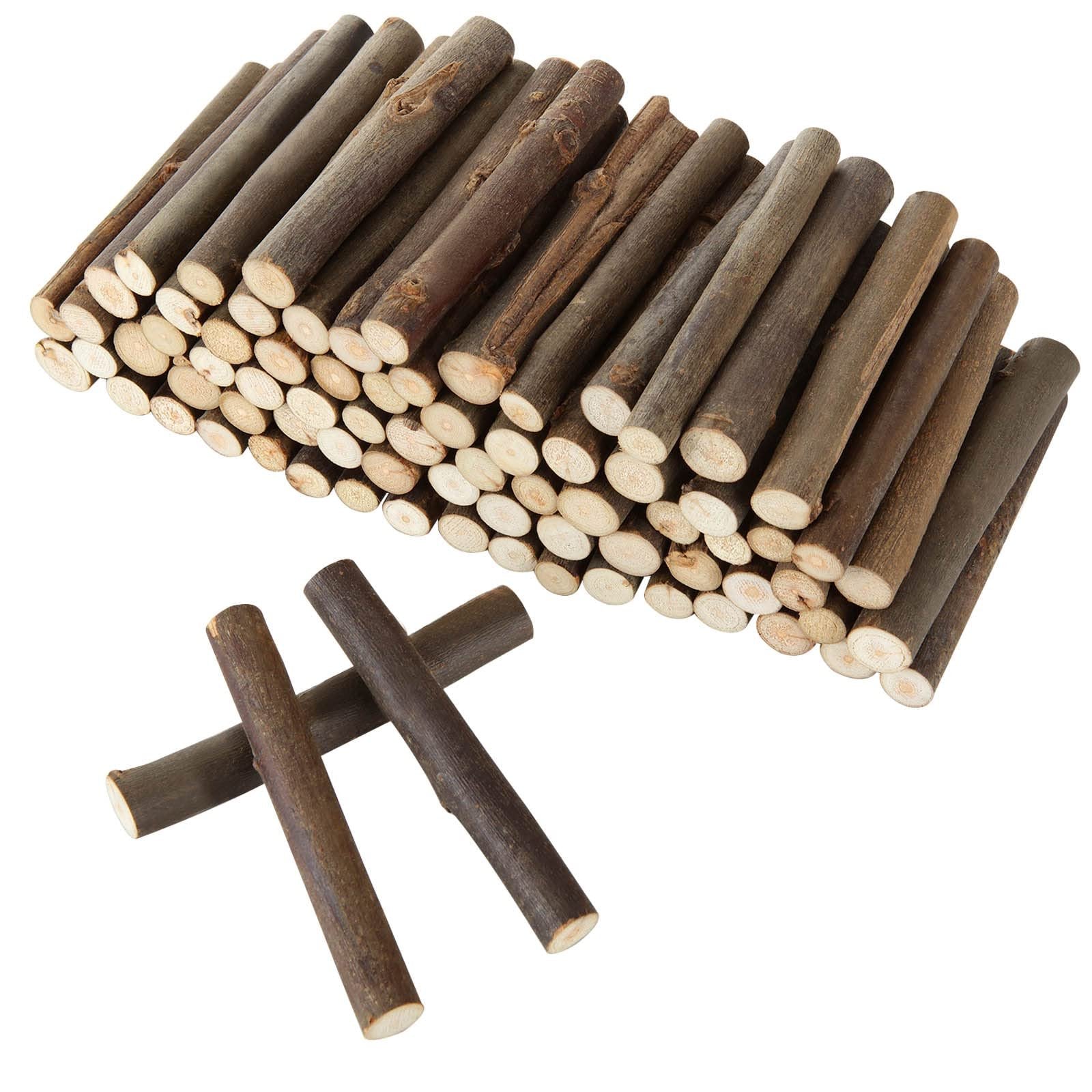 Pile of natural birch wood log sticks for crafts, with two sticks crossed in the foreground.