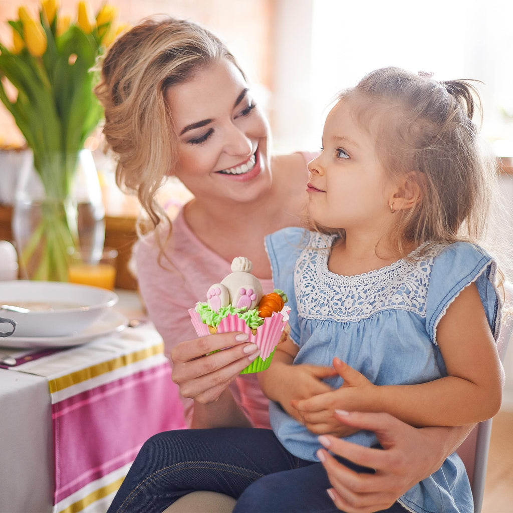 Mother and daughter looking at a decorated cupcake with bunny ears and carrots