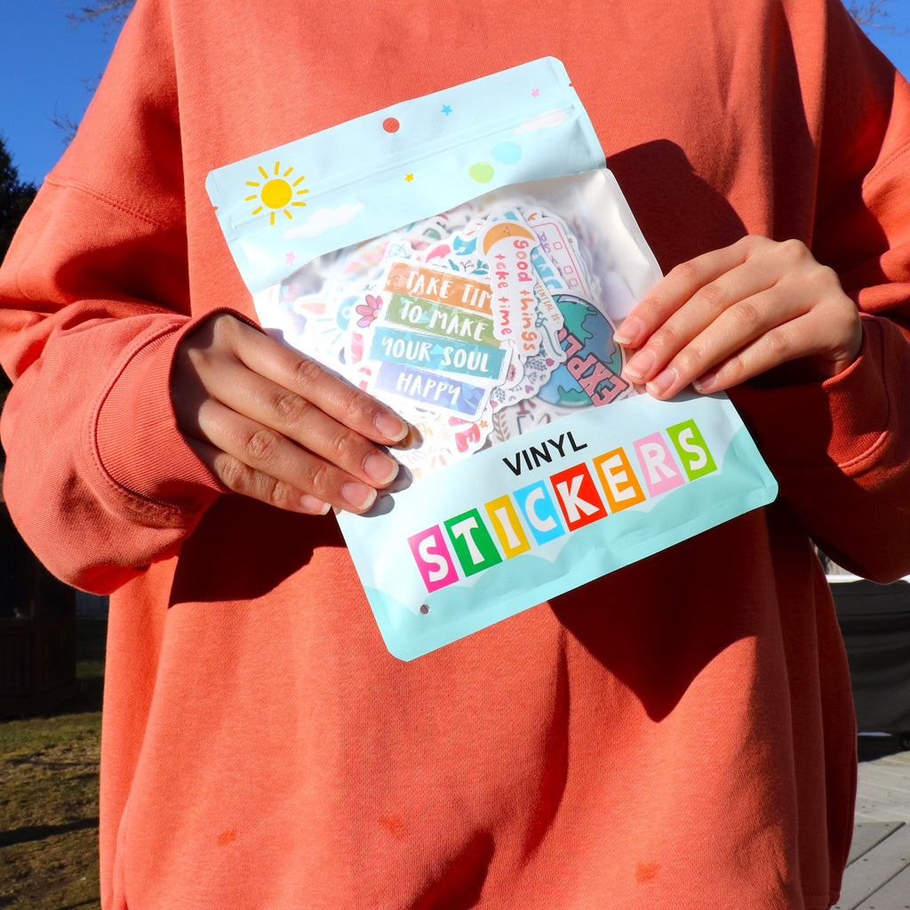 Person holding a package of motivational vinyl stickers with inspirational quotes and boho designs.