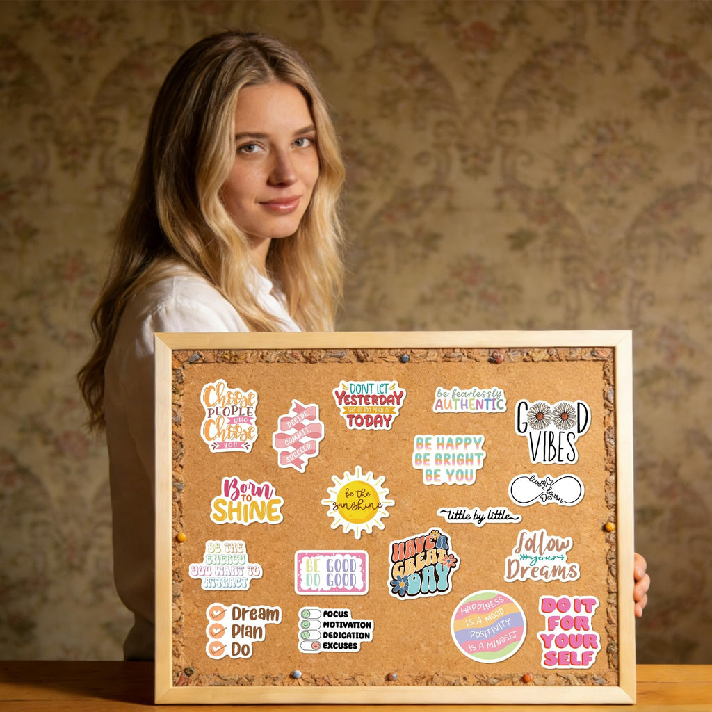 Woman holding a corkboard with motivational vinyl stickers. Stickers feature quotes like 'Choose people who choose you' and 'Good Vibes'.