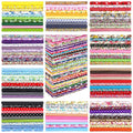 Stacks of colorful fabric squares with various patterns including floral, polka dots, gingham, and stars.