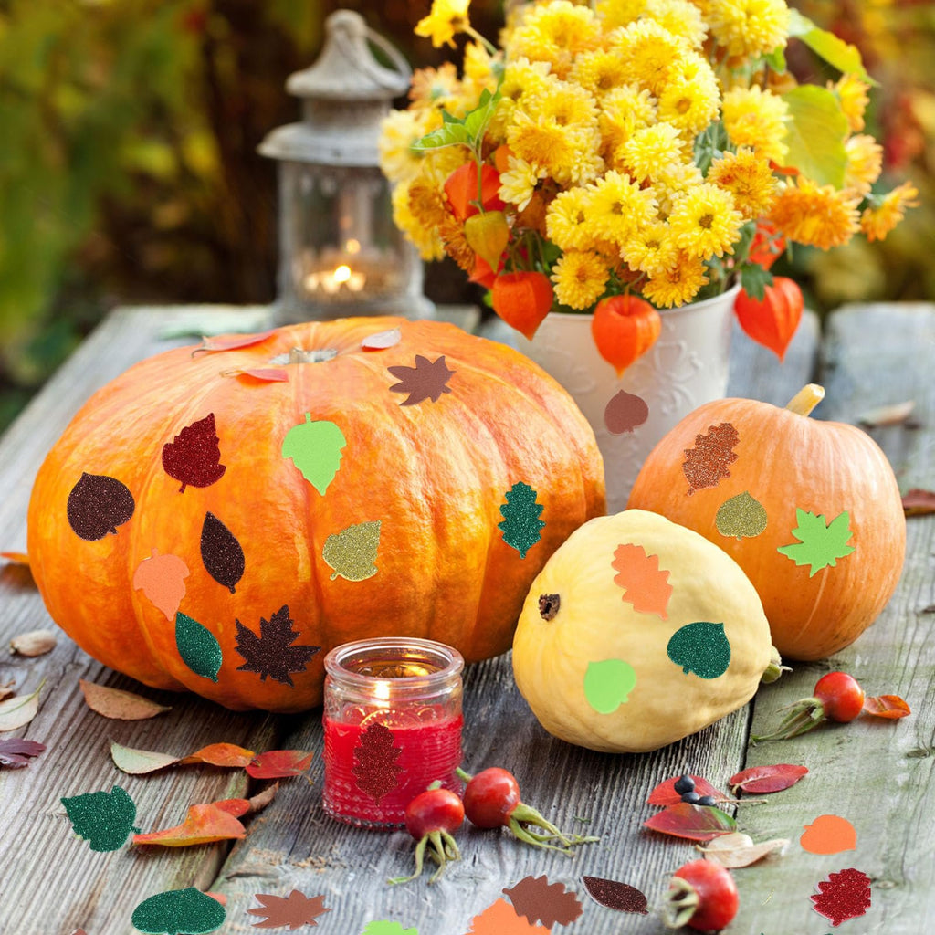 Assorted glitter foam leaf stickers applied to pumpkins and a candle jar for fall decoration.