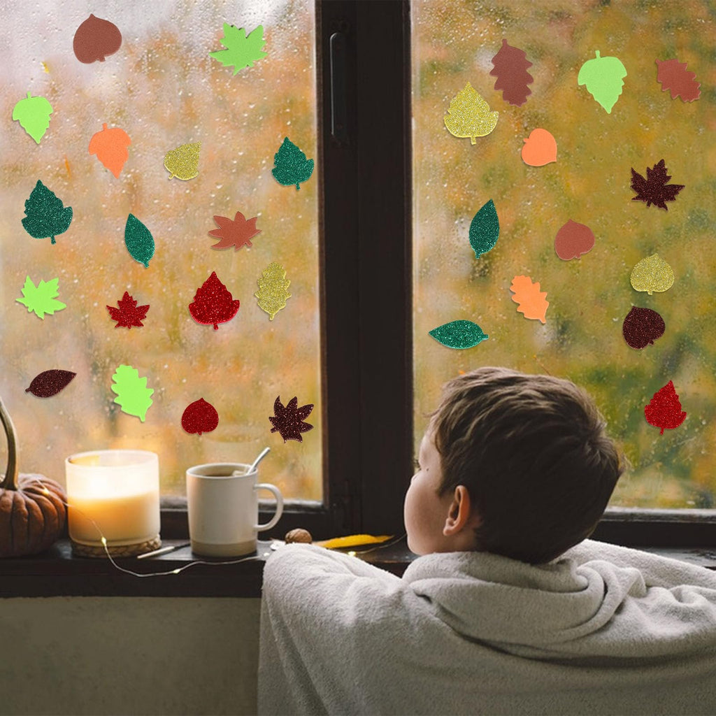 Child looking out a rainy window decorated with colorful glitter foam fall leaf stickers.