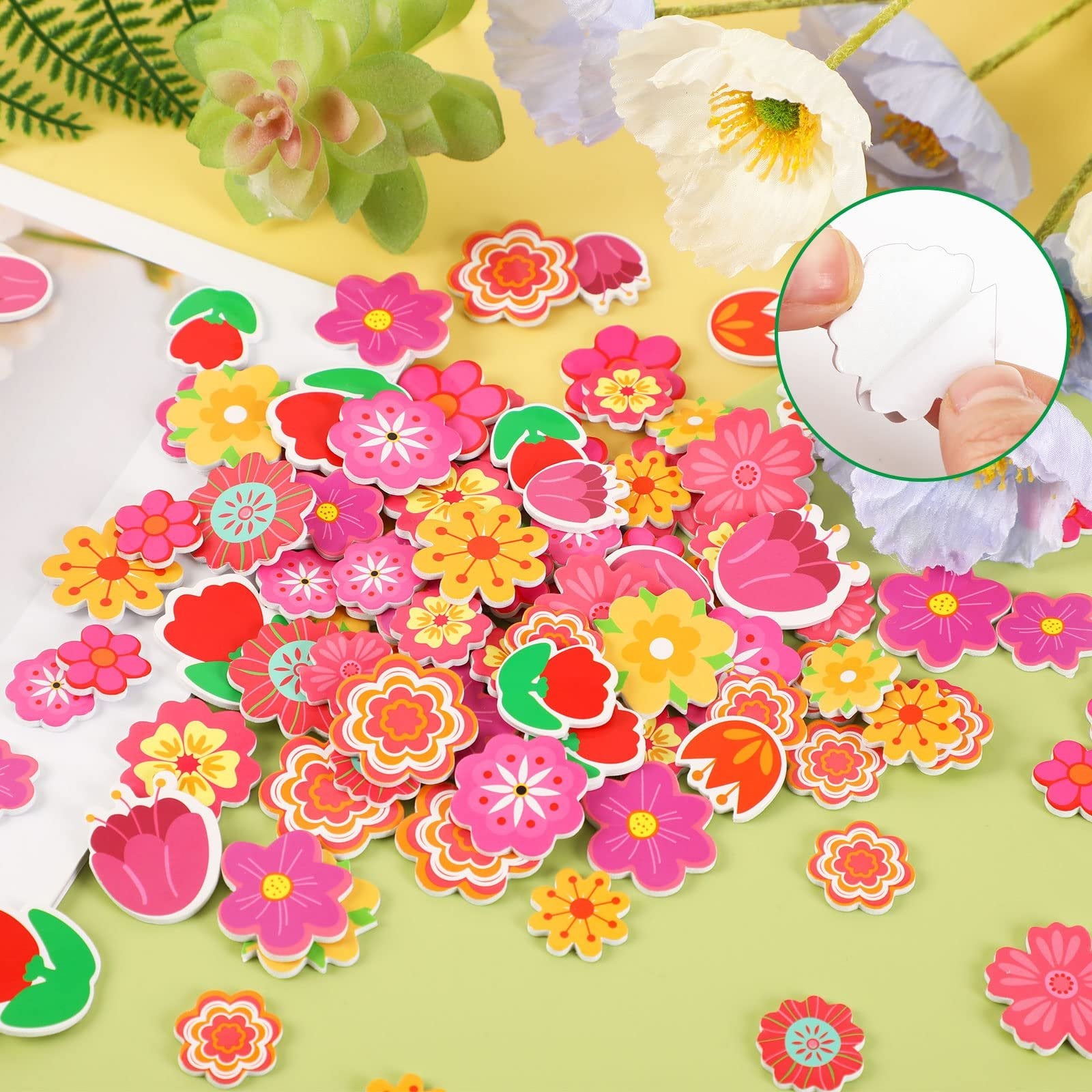 Assorted self-adhesive foam flower stickers in various colors and styles, with a close-up inset showing hands peeling one off its backing.