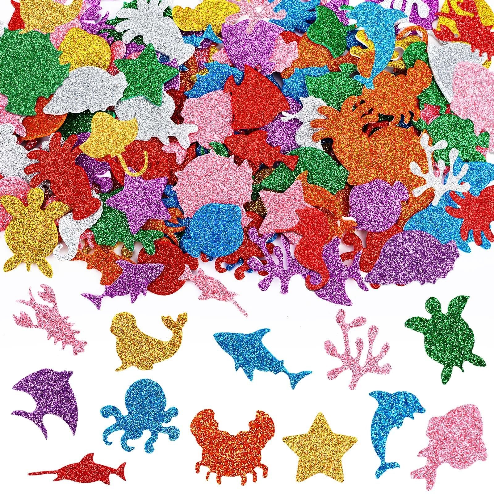 Assortment of glitter sea animal foam stickers including sharks, dolphins, turtles, crabs, octopuses, and starfish on a white background.