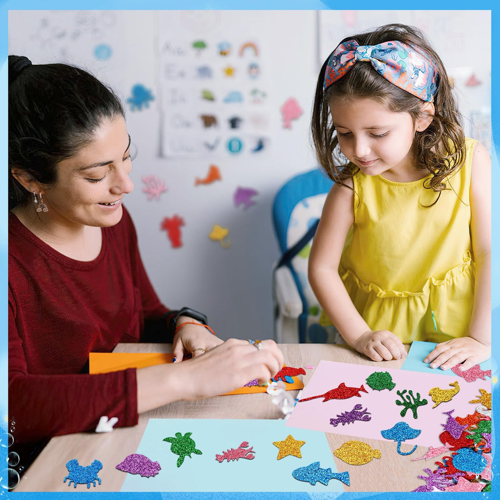 Woman and child crafting with glitter sea animal foam stickers on a table