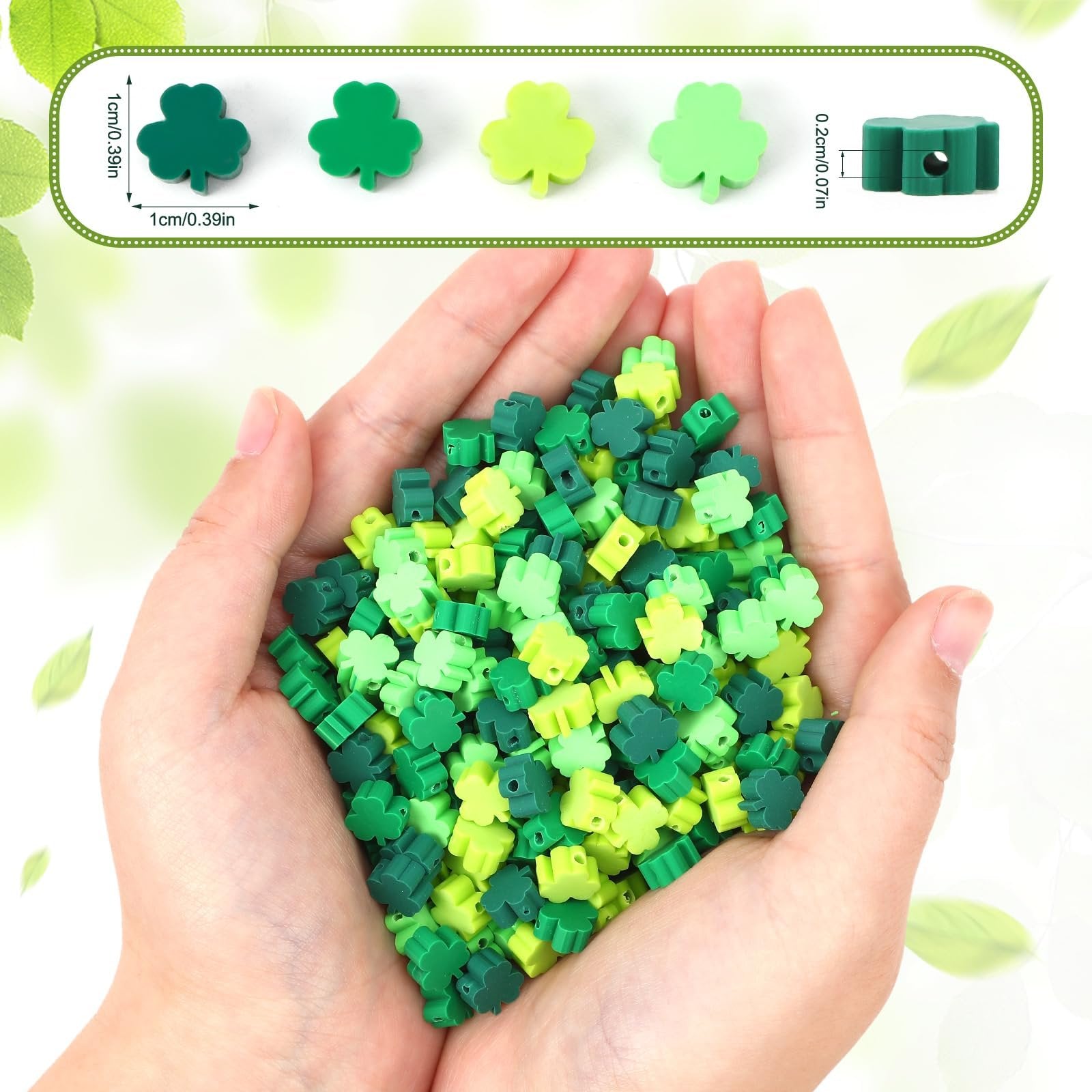 Hands holding a pile of green shamrock-shaped polymer clay beads for jewelry making