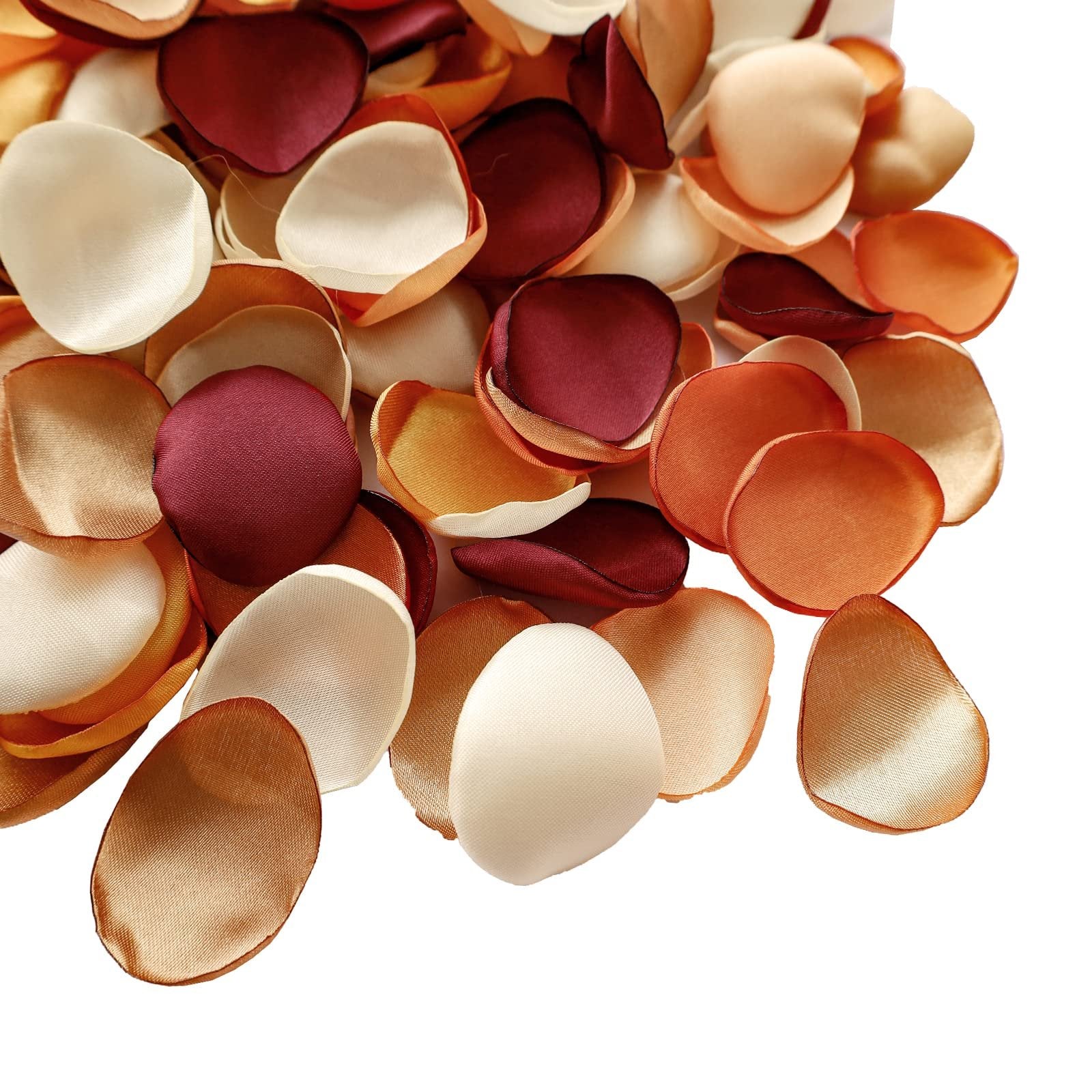 Pile of terracotta satin rose petals in various shades of cream, tan, rust, and burgundy.