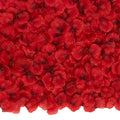 Pile of dark red artificial silk rose petals, close-up top-down view.