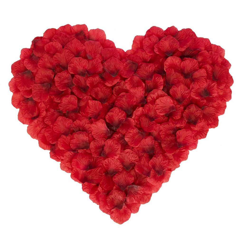 Heart shape made from dark red artificial silk rose petals on a white background