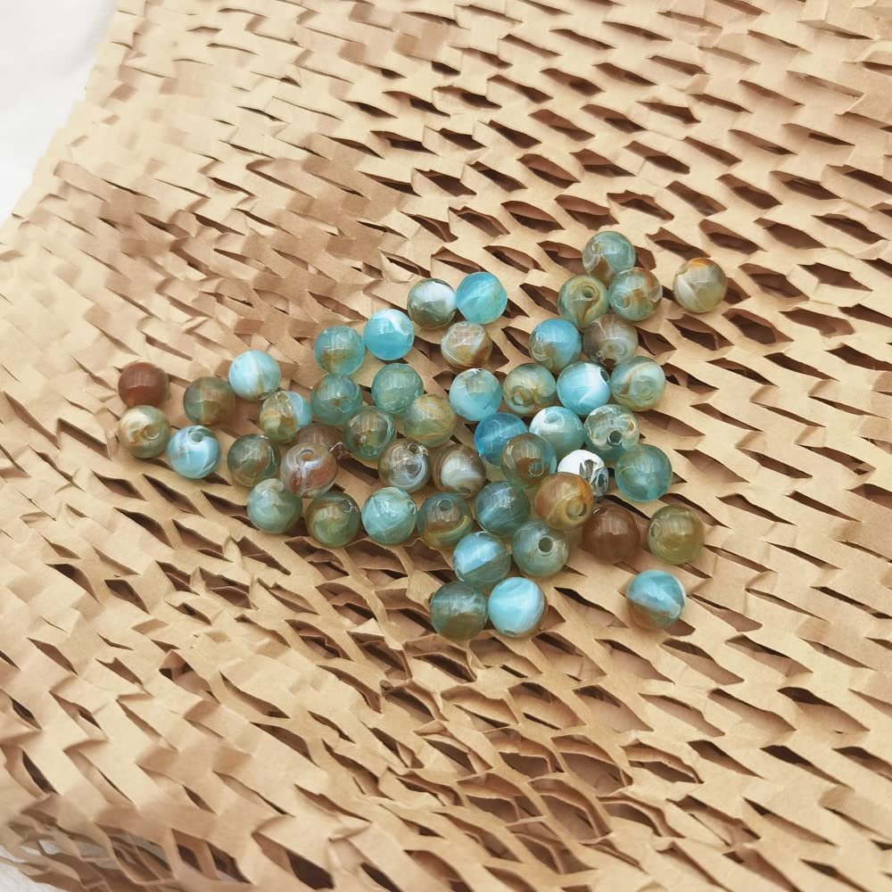 Scattered 8mm marble pattern acrylic beads in blue and brown tones on brown textured paper.