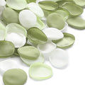 Pile of faux silk rose petals in pale green and white, scattered on a white background.