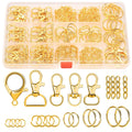 Gold keychain making kit components including clasps, rings, chains, and jump rings in a clear organizer box and laid out separately.