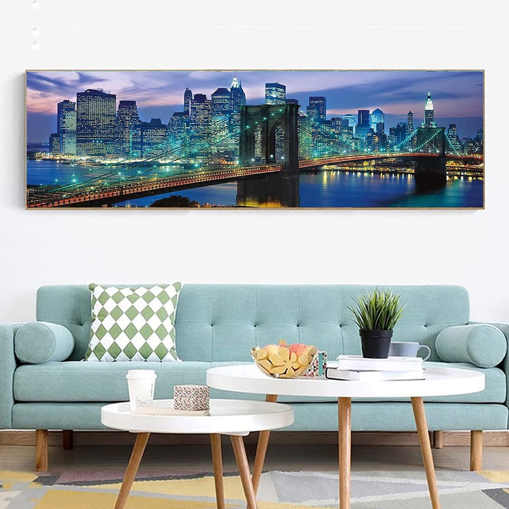 Diamond painting kit of Brooklyn Bridge at night, displayed above a sofa.