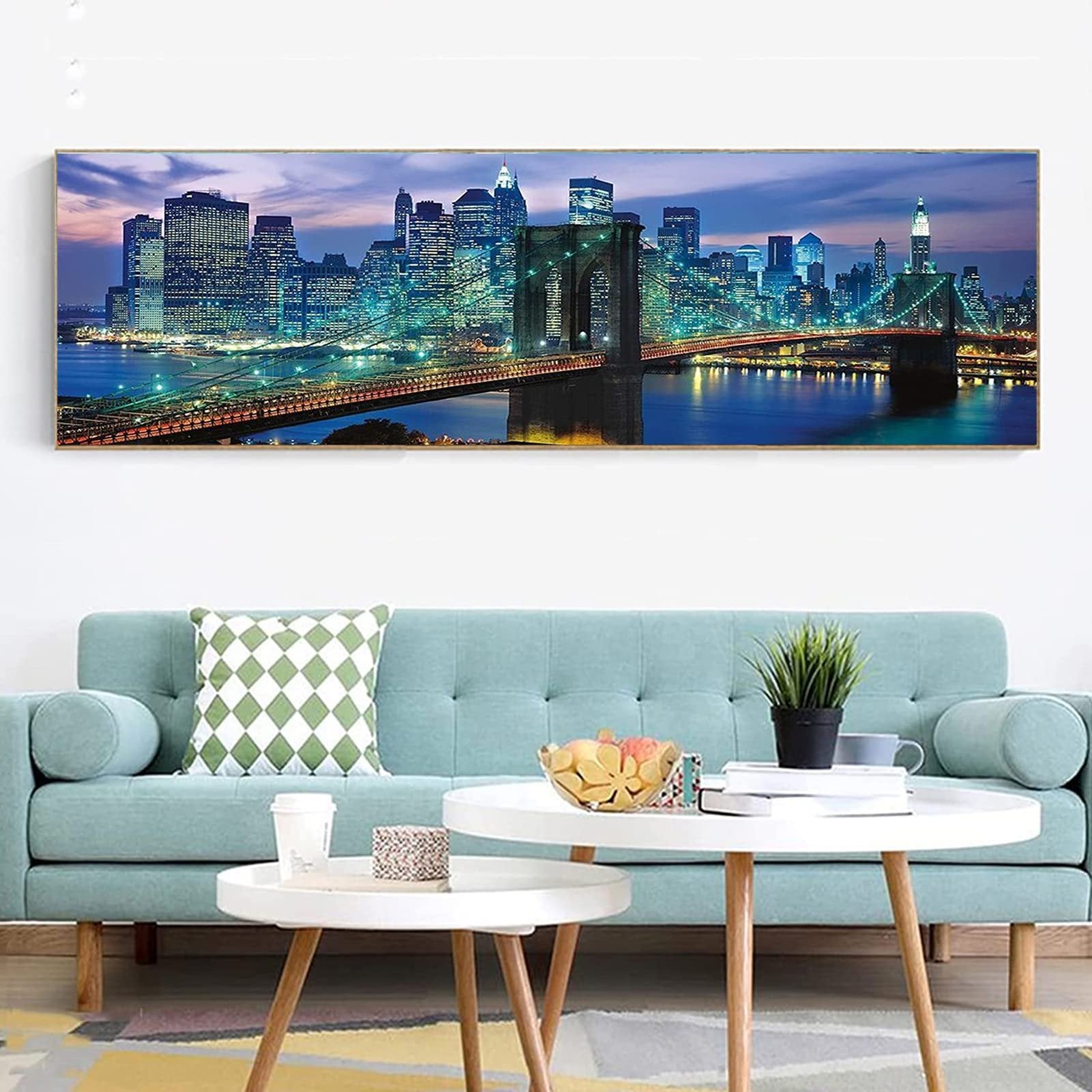 Diamond painting kit of Brooklyn Bridge at night, displayed above a sofa.