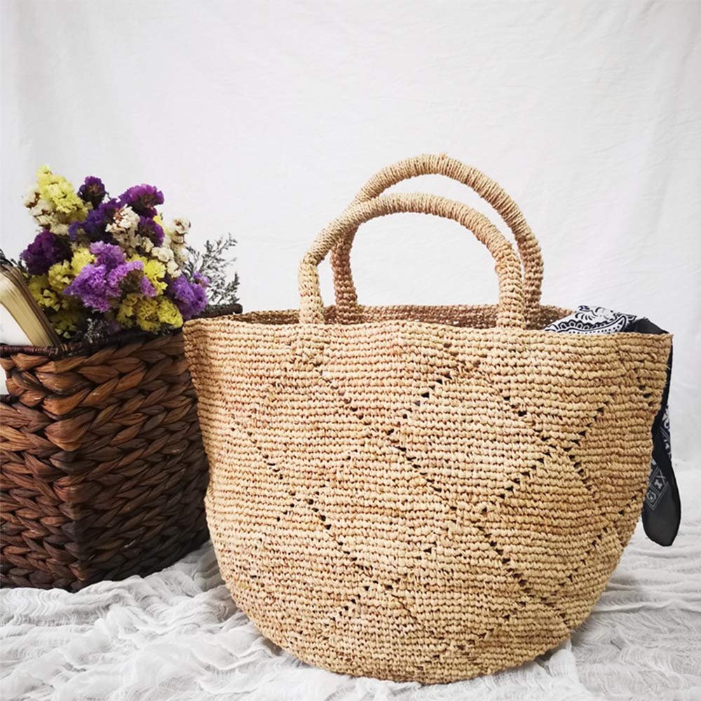 Woven straw tote bag with diamond pattern and two handles, next to a basket of flowers.