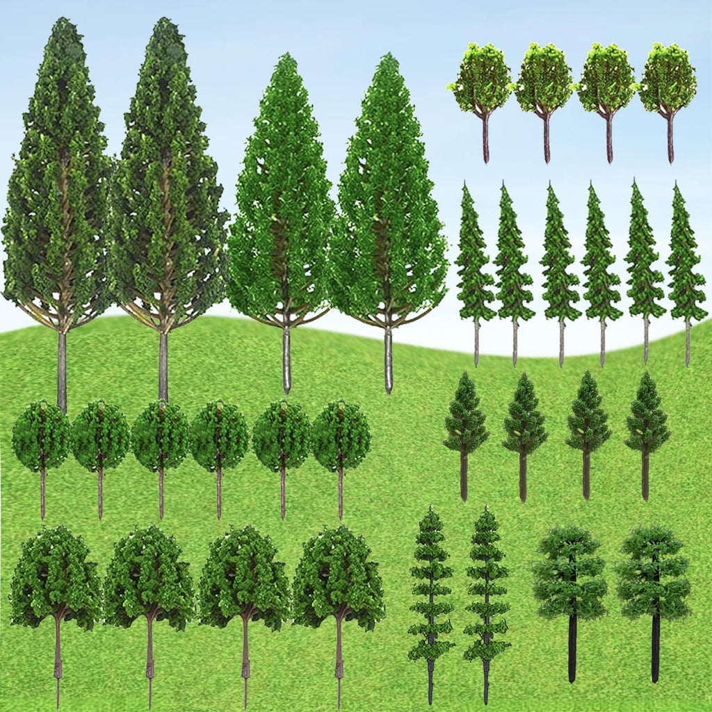 Collection of 32 miniature model trees in various styles and sizes, arranged on a green grassy background with a blue sky.