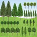 Collection of 32 miniature model trees in various styles and sizes, arranged on a green grassy background with a blue sky.