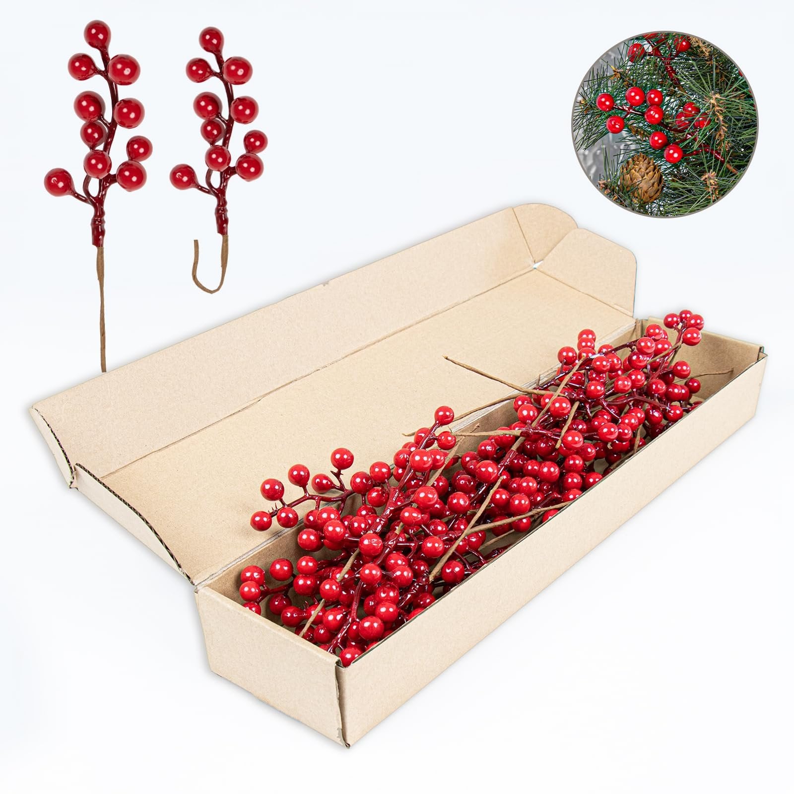 Artificial red berry stems with holly berries and pine cone in a circular inset, with stems in an open box