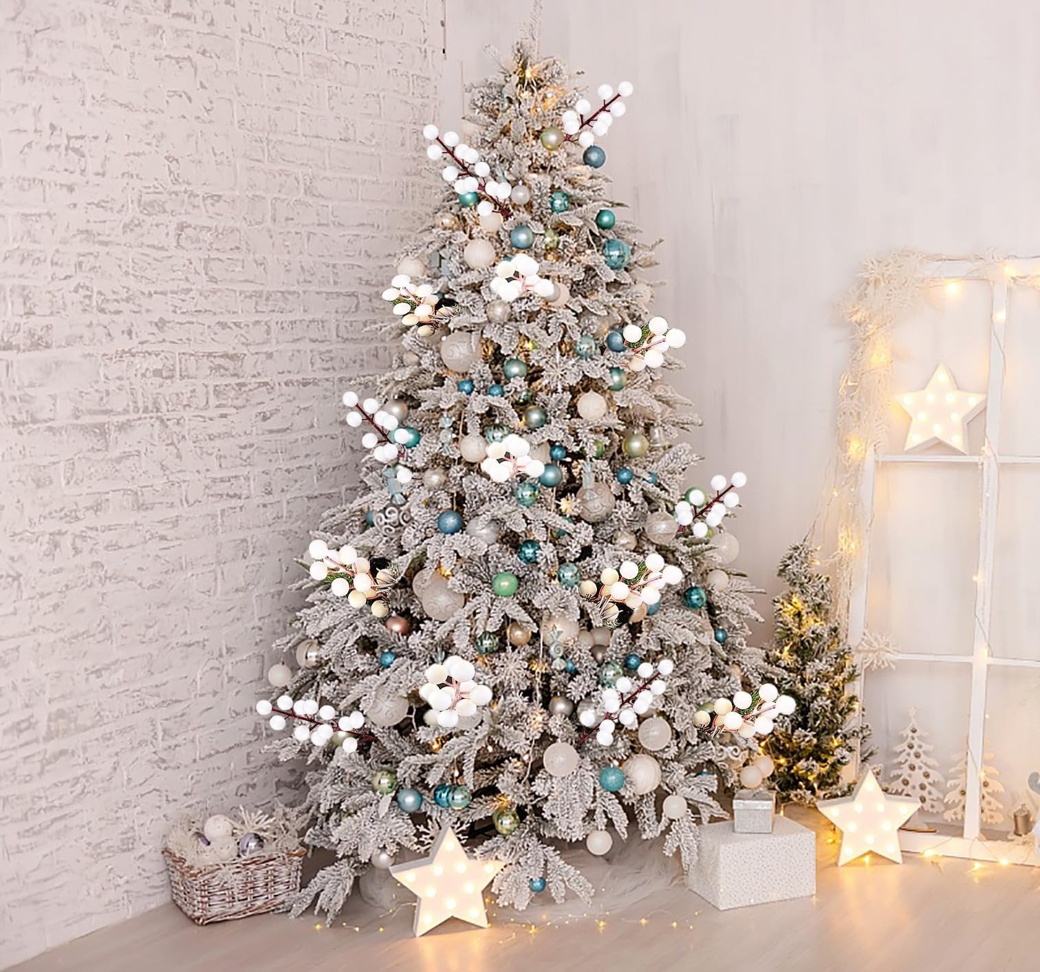 Flocked Christmas tree decorated with white berry stems, blue and silver ornaments, and lights.