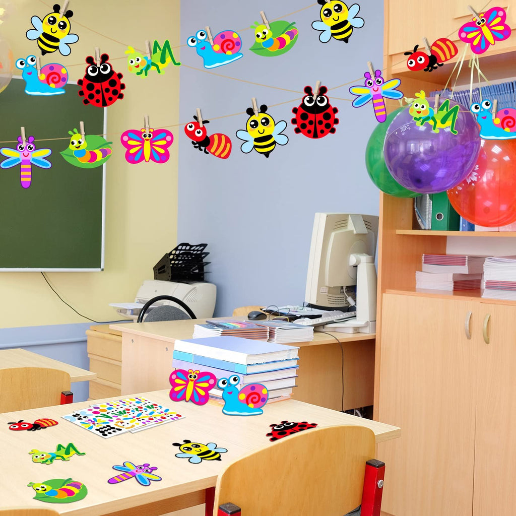 Classroom scene with bug-themed craft cutouts hanging on a string and scattered on desks, with balloons and books visible.
