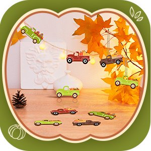 Unfinished wooden fall truck and pumpkin cutouts arranged in a decorative display with autumn leaves and string lights.