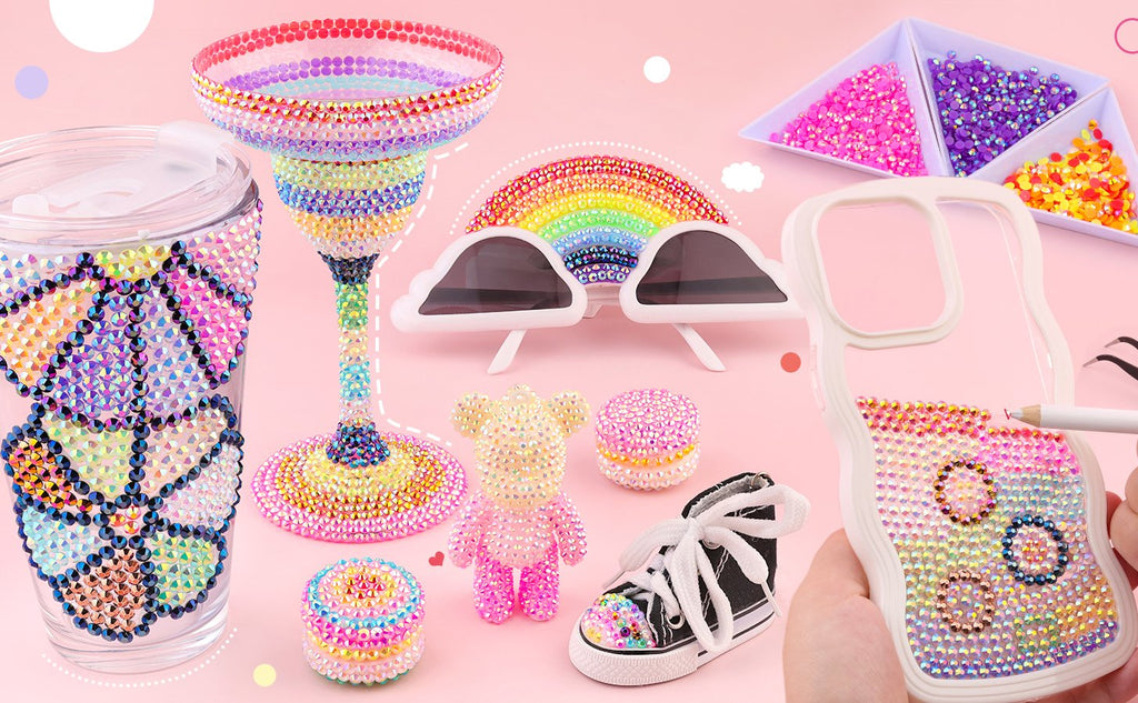 Assortment of DIY rhinestone craft projects including a decorated tumbler, wine glass, sunglasses, teddy bear, sneaker, and phone case.