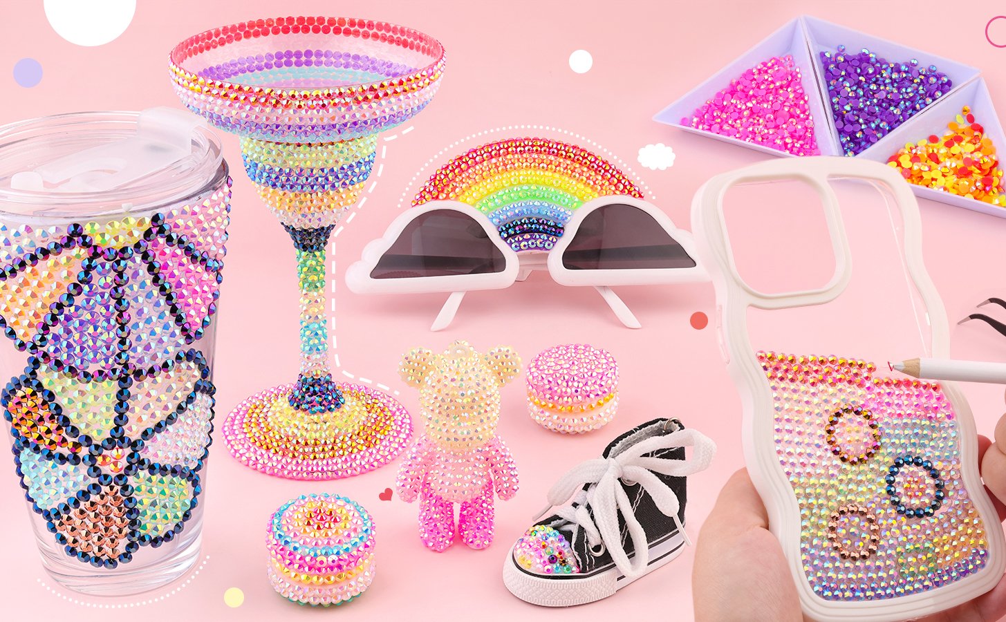 Assortment of DIY rhinestone craft projects including a decorated tumbler, wine glass, sunglasses, teddy bear, sneaker, and phone case.