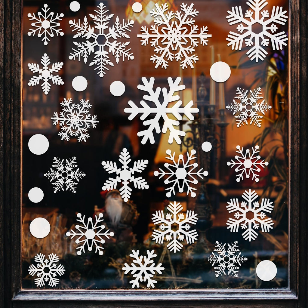 White snowflake window decals applied to a glass window with a dark wooden frame, showing various snowflake designs and some solid circles.