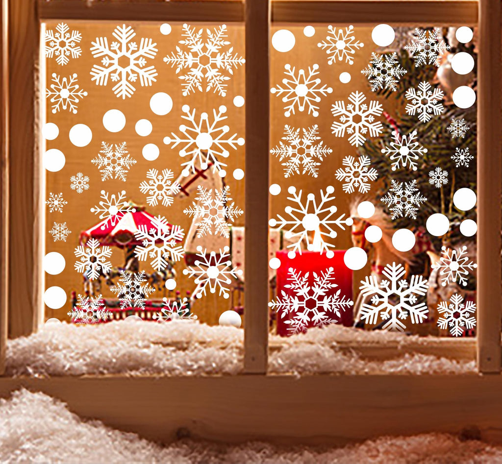 Christmas window decals with snowflakes and circles applied to a window with a festive scene behind it.
