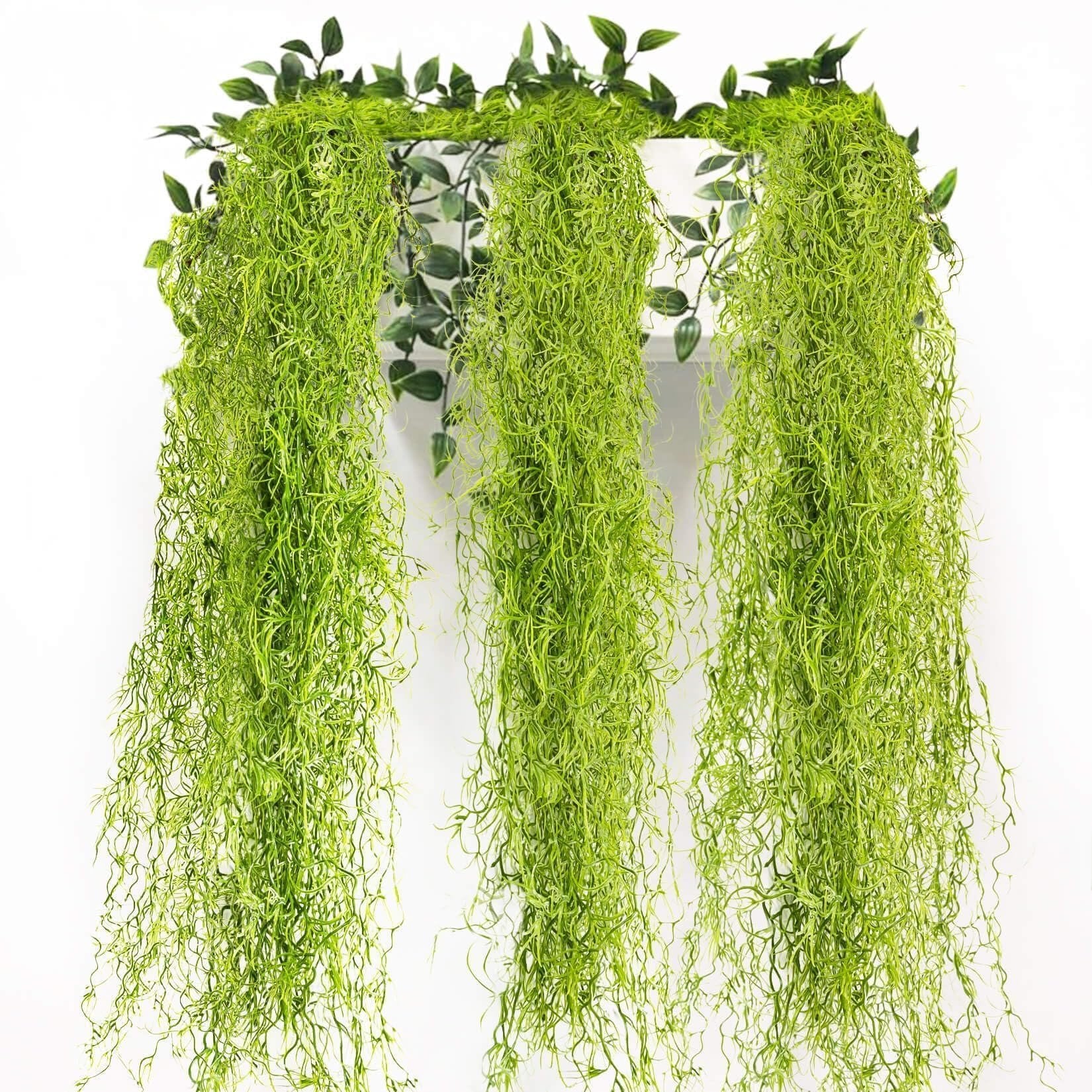 Three strands of artificial Spanish moss garland hanging against a white background with green leaves at the top.