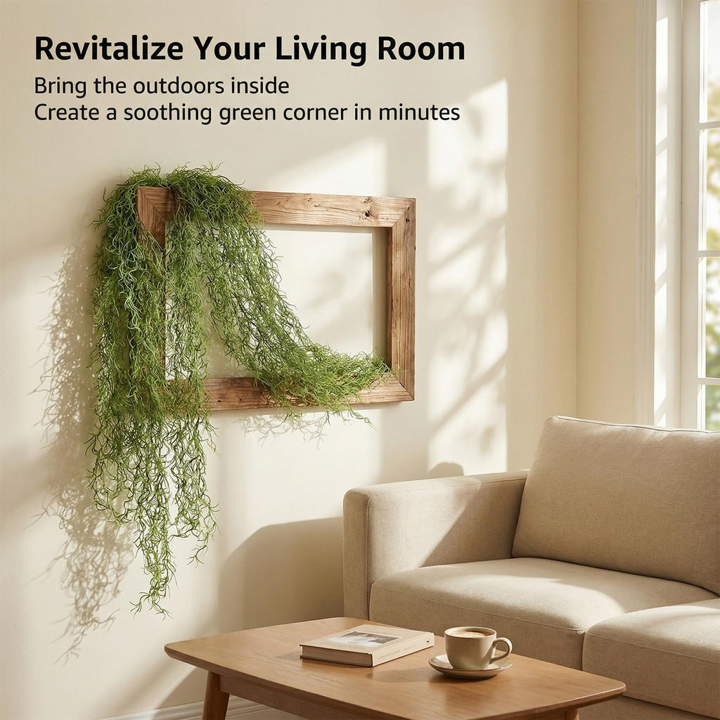 Artificial Spanish moss garland draped over a wooden frame on a wall, with a sofa and coffee table in the foreground.