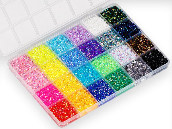 Open clear plastic organizer case filled with colorful flatback rhinestones in various sizes and shades.