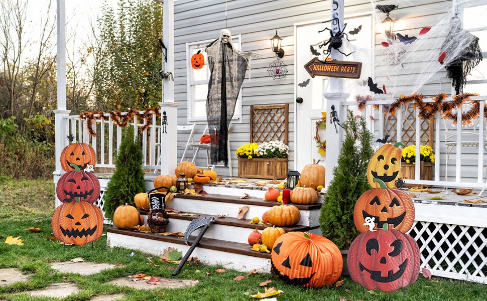Stacked Halloween pumpkin garden stakes and various pumpkins on a decorated porch