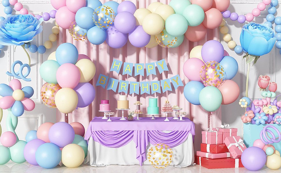 Pastel rainbow balloons and decorations for a birthday party, including a 'Happy Birthday' banner and cakes.
