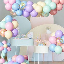 Pastel rainbow latex balloons with gold confetti and ribbon arranged in garlands and bouquets for a party.