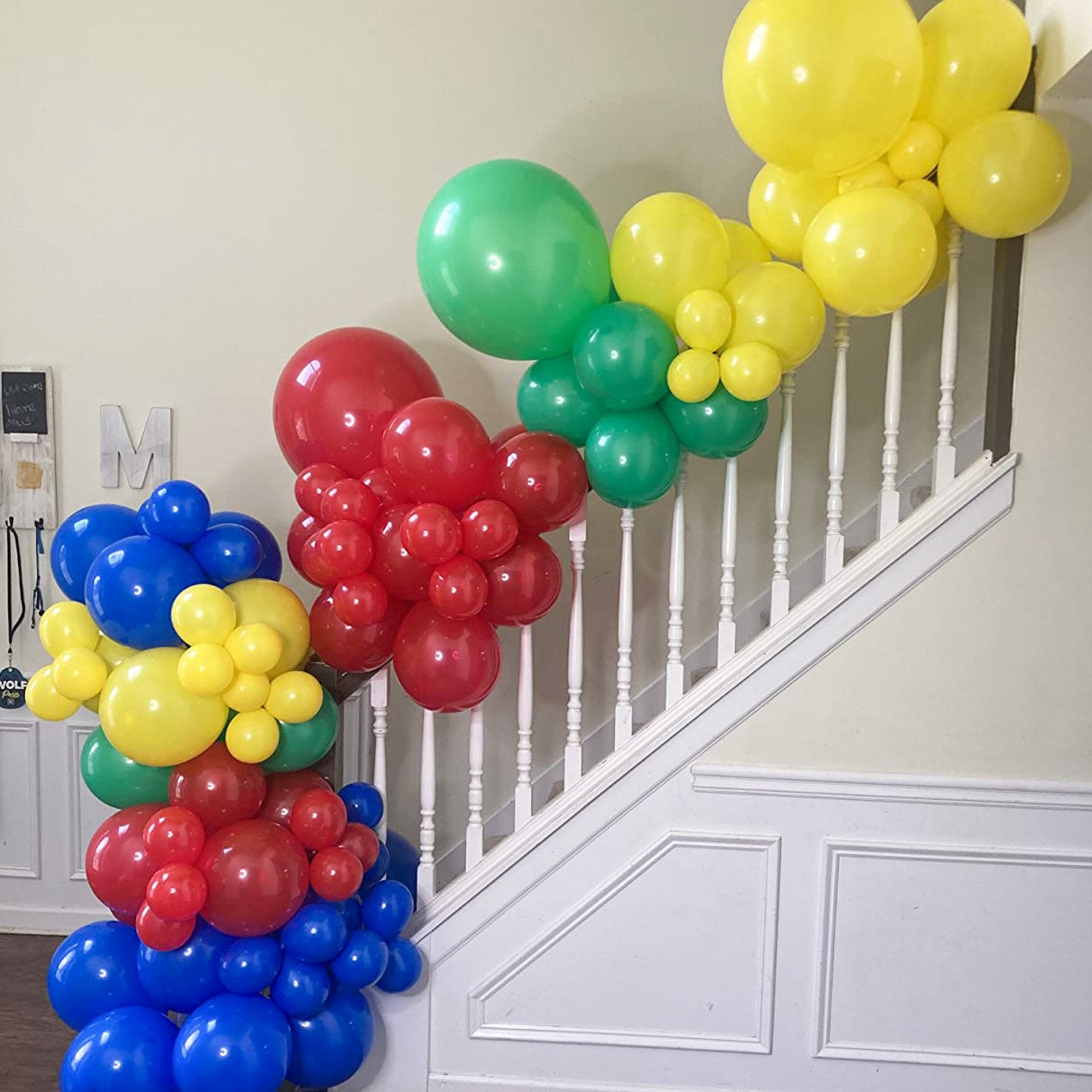 Balloon garland in red, yellow, green, and blue colors decorating a staircase